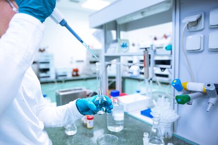 Laboratory scientist conducting a research, experiments, chemist adjusts samples in a petri dish, chemistry conceptの写真素材