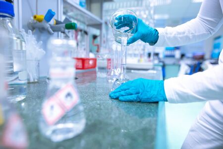 Laboratory scientist conducting a research, experiments, chemist adjusts samples in a petri dish, chemistry conceptの写真素材