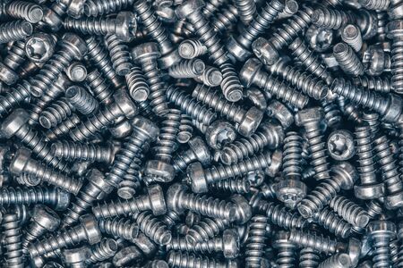 A lot of tapping metal or iron screws, screws as a background, wallpaper or texture
