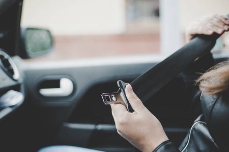 passenger woman fastening seat belt in the car, safety concept against car crashの写真素材