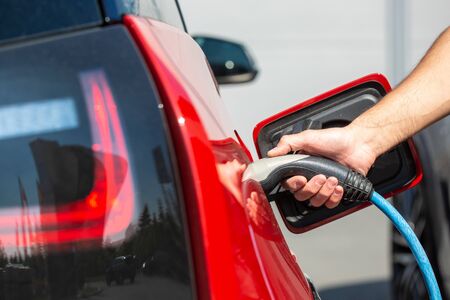 Eco-friendly alternative energy concept, automatic electric car charging at charging station, energy...