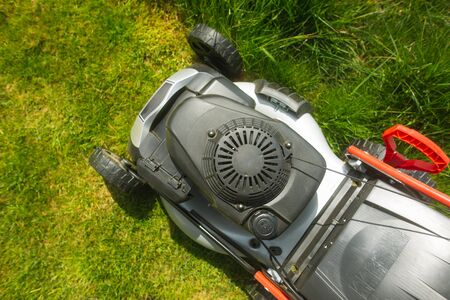 Close up of lawn mower on the grass, read yfor cutting the grass in garden, gardening conceptの写真素材