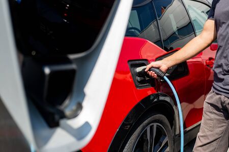 Eco-friendly alternative energy concept, automatic electric car charging at charging station, energy...