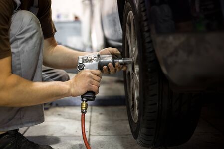 Professional car servis man changing the wheel of carの写真素材