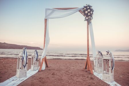 Wedding ceremony on a tropical beach in white. Arch decorated with flowers on the sandy beachの写真素材