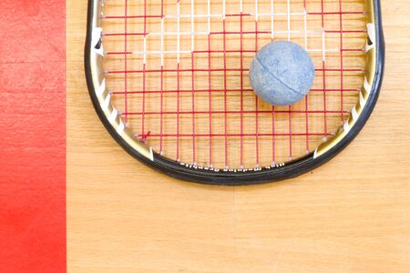 Close up of a squash racket and ball on the wooden background, sport conceptの写真素材