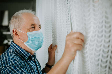 Senior man quarantined at home during coronavirus pandemic, stay safeの写真素材