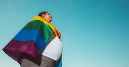 Pregnant lesbian woman with gay pride, rainbow flag, LGBTQ backgrounds with extra copy space, pregnancy LGBTQ conceptの写真素材