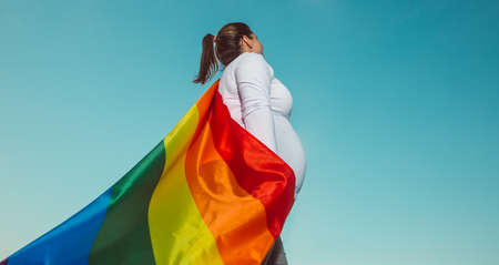 Pregnant lesbian woman with gay pride, rainbow flag, LGBTQ backgrounds with extra copy space, pregnancy LGBTQ conceptの写真素材