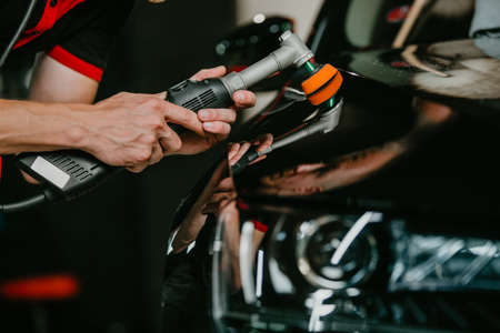 Close up of car detailist hands, cleaning or pilishing the car by poliermaschine, car detailing conceptの写真素材