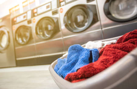 Basket with dirty clothes or laundry in the laundry room with kind of washing machineの写真素材