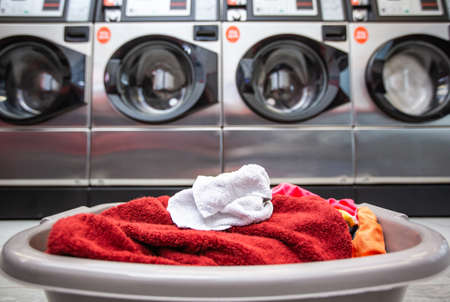 Basket with dirty clothes or laundry in the laundry room with kind of washing machineの写真素材