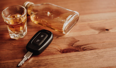Close up of car keys and an alcohol on the table, alcoholism