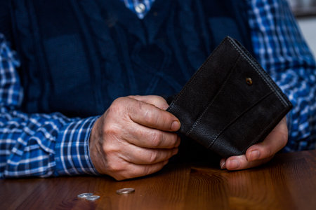 An old senior man showing an empty wallet without money during covid-19, coronavirus pandemic,...