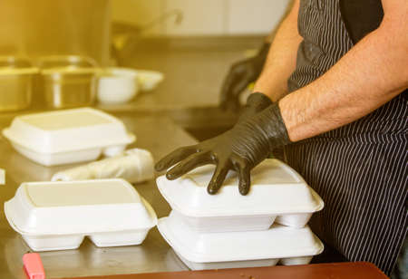 Chef preparing dish to a box in the restaurant for food delivery service to home, online orderingの写真素材
