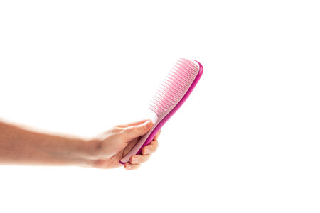 Woman hand with pink hair comb isolated on the white background, bannerの写真素材