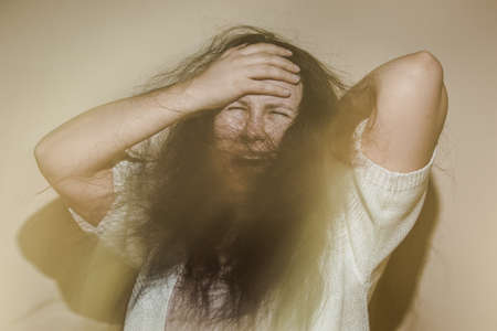 Young woman suffering from a severe depression or anxiety disorder, distres and anguish conceptの写真素材