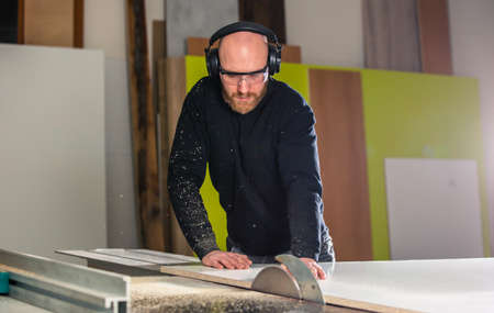 Joinery, woodworking and furniture making, professional carpenter cutting wood in the carpentry...