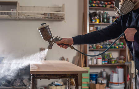 Joinery, woodworking and furniture making, professional carpenter varnishing wood in the carpentry shop, industrial conceptの写真素材