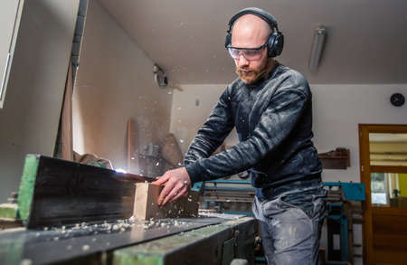 Joinery, woodworking and furniture making, professional carpenter cutting wood in the carpentry...