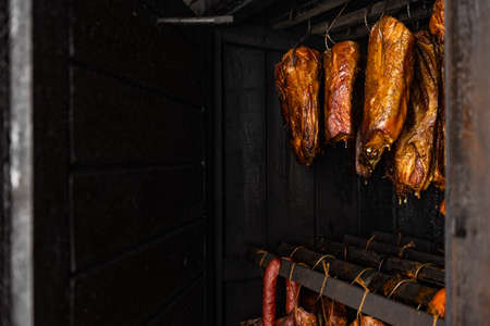 Close up of smoked meat and belly or beech meat with dark crust in the smokehouse or smoker, food conceptの写真素材
