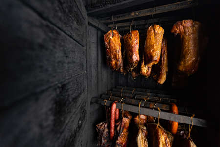 Close up of smoked meat and belly or beech meat with dark crust in the smokehouse or smoker, food conceptの写真素材