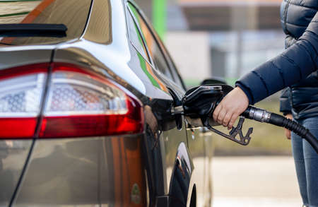 Process of refueling a car fill with petrol fuel at the gas station, pump filling fuel nozzle in...