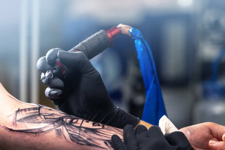 Close up of a tattoo artist tattoos a black tattoo with paint, tattoo fill out a tattoo circuit, tattoo processの写真素材