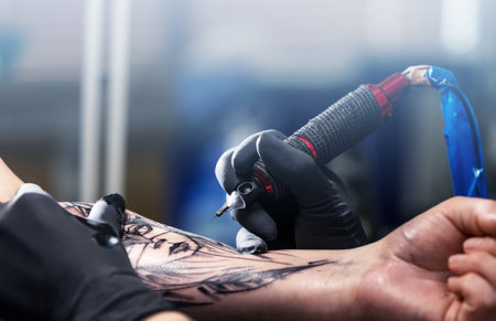 Close up of a tattoo artist tattoos a black tattoo with paint, tattoo fill out a tattoo circuit, tattoo processの写真素材