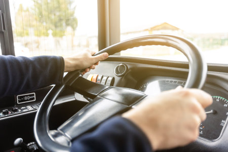 Hands of the driver in a modern bus according to the ride, detail of the bus drivers steering wheel and driving a passenger bus, transportation conceptの写真素材