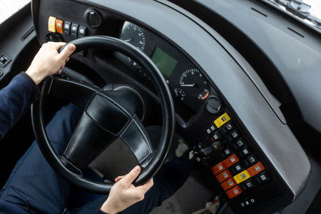 Cockpit or cabin of public transport, bus driver holding steering wheel, concept of urban public transportationの写真素材