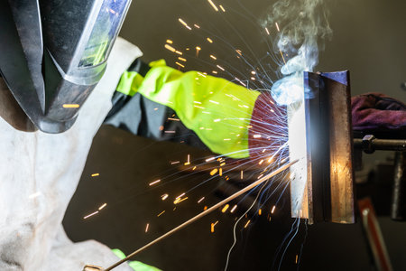Detail to welding process of metal parts, using a welding machine, bright sparks and flashes,...