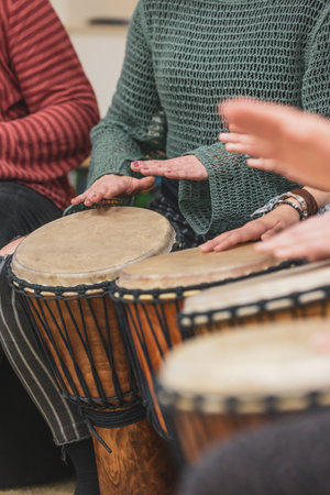 Group of people playing drums during a music therapy lessons, jembe drum, drumming conceptの写真素材