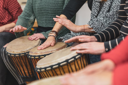 Group of people playing drums during a music therapy lessons, jembe drum, drumming conceptの写真素材