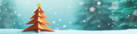 Orange origami christmas tree standing on snowy surfaceの素材