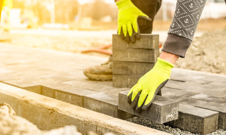 Construction worker paving a walkway with concrete or brick paversの写真素材