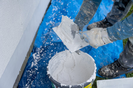Worker applying renovation plastering stucco to exterior wallの写真素材