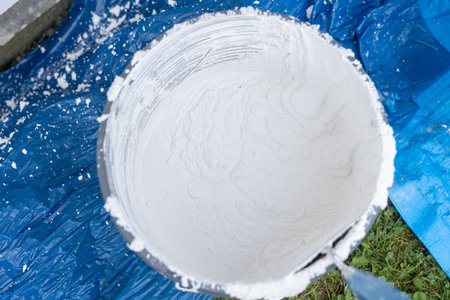 Mixing white plaster powder in construction bucket for renovationの写真素材