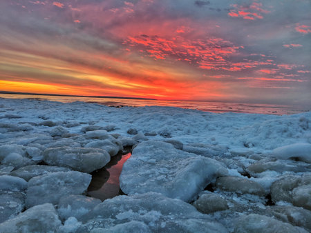 Ice on Lake Michigan with Red Sunset Behindの写真素材