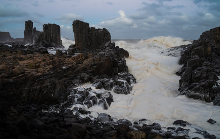 Waves and Rocky Beach: Heritage Bombo Quarry Shines in the Blue Hour over Latite Basalt near Kiamaの写真素材