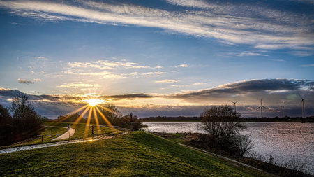 Before the Big Rain: Tranquil Sunrise Over the River and Lush Green Spaceの写真素材