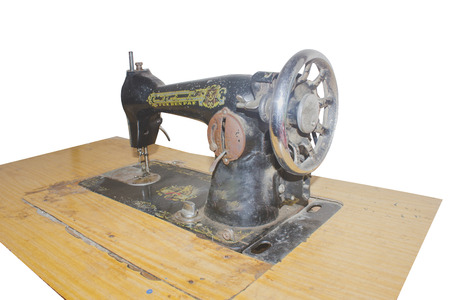 sewing old machine with black color and wood table close up of head machine with clipping path