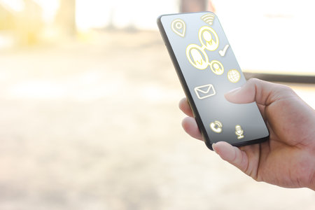 hand holding the smartphone touch the  screen to connection people for business marketing with social media icons  or  online shopping of new technology with copy spaceの写真素材