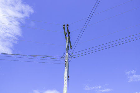 Electric poles with electric cables and power lines on a clear sky backgroundの写真素材