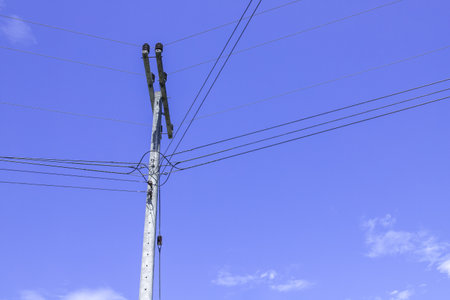 Electric poles with electric cables and power lines on a clear sky backgroundの写真素材