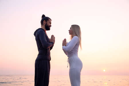 a guy and a girl on the shore, hands namasteの写真素材