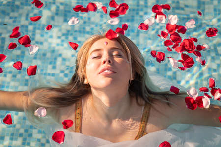 beautiful woman in a pool with flowersの写真素材
