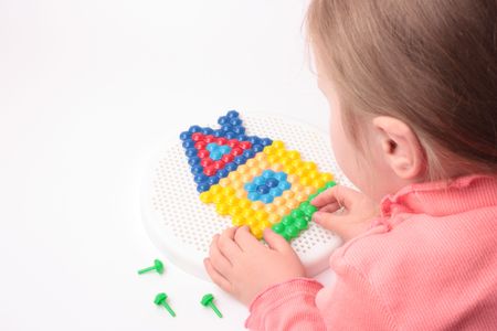 Girl collects house of mosaics on a white background. の写真素材