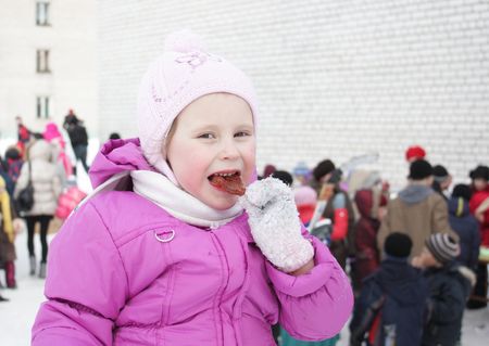 The girl at the fair eating sugar candy.の写真素材
