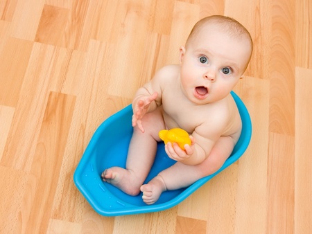 Surprised kid sitting in a bathtub.